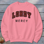 Pink crewneck sweatshirt with "LORDY MERCY" text in a collegiate font.