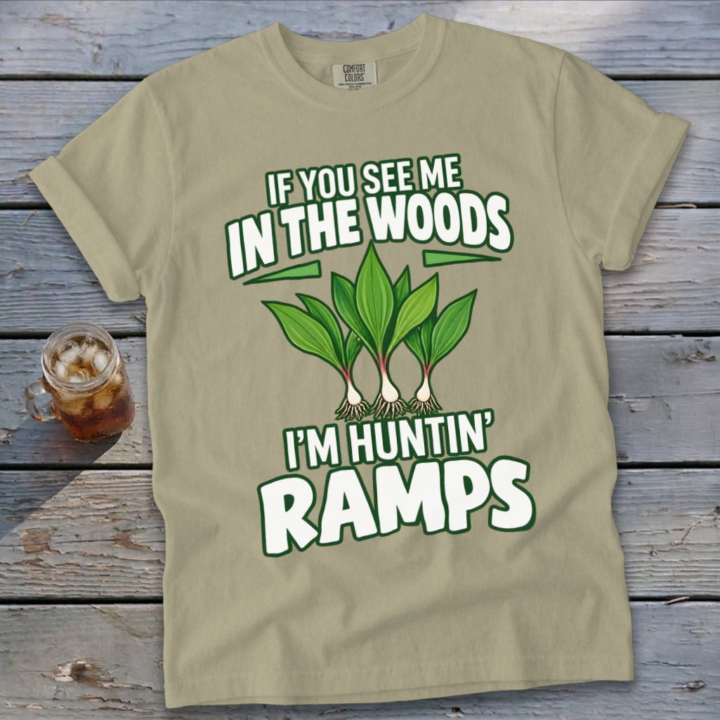 A tan t-shirt printed with the text "IF YOU SEE ME IN THE WOODS I'M HUNTIN' RAMPS" above and below an illustration of wild ramps.