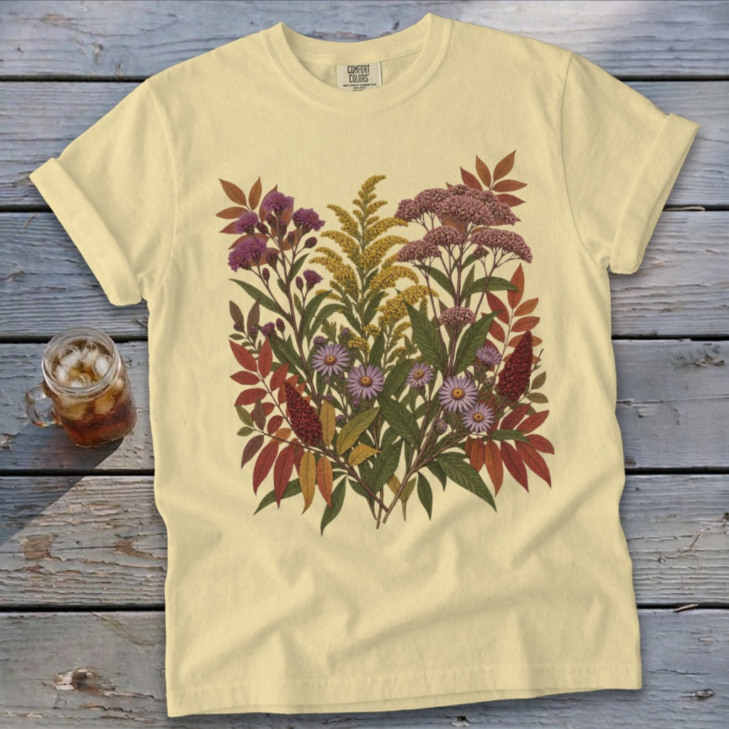 Yellow t-shirt with a colorful botanical illustration featuring purple and pink flowers and red leaves.