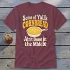Maroon t-shirt featuring the text "Some of Y'all's Cornbread Ain't Done in the Middle" and a skillet graphic.