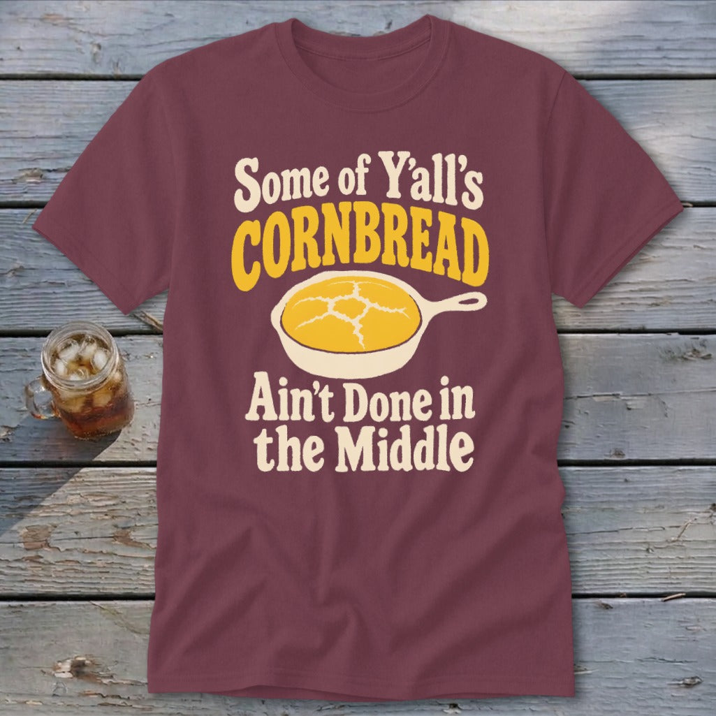 Maroon t-shirt featuring the text "Some of Y'all's Cornbread Ain't Done in the Middle" and a skillet graphic.