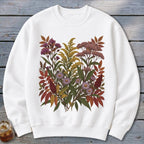 White crewneck sweatshirt with a colorful botanical print of wildflowers and autumn leaves.