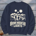 Navy blue crewneck sweatshirt featuring a graphic of three figures looking at mountain lights, with text reading Brown Mountain Lights.