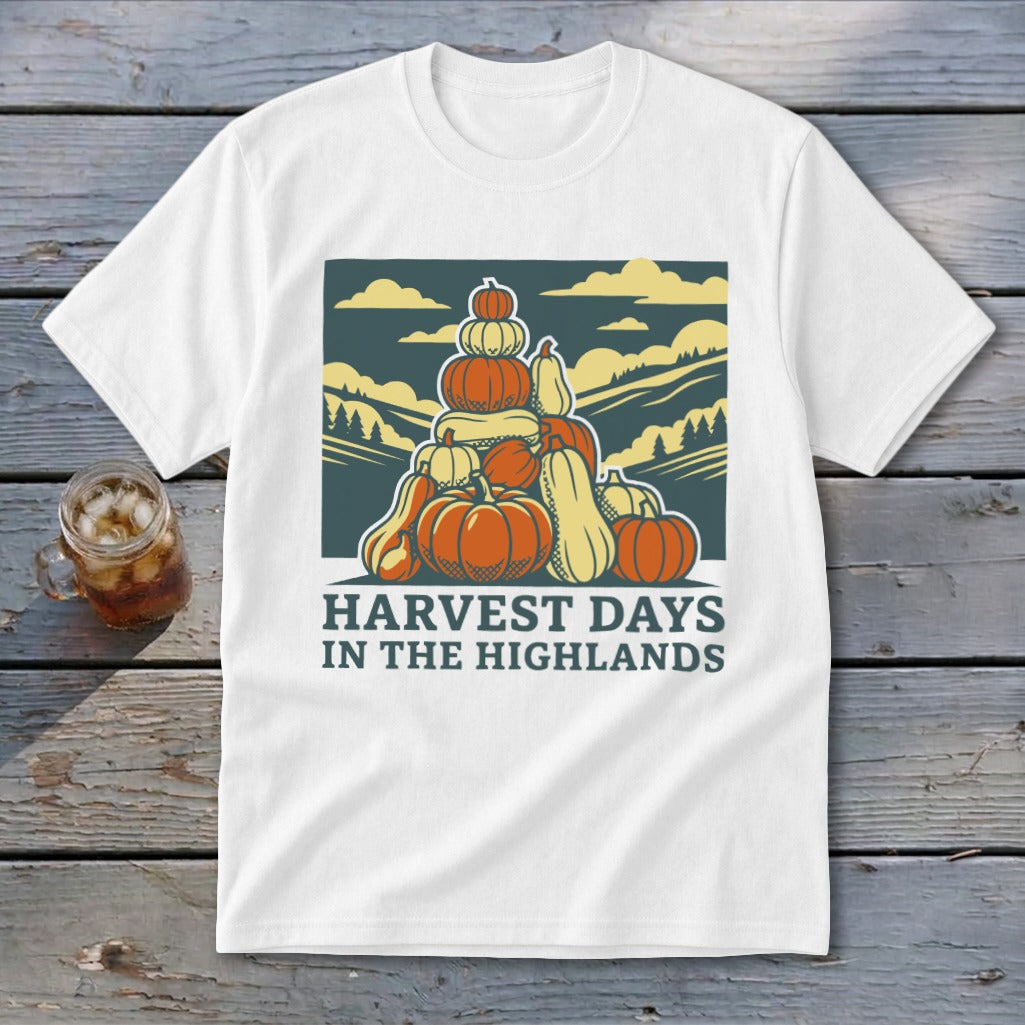White t-shirt featuring a retro graphic of a pumpkin stack and mountains with the text HARVEST DAYS IN THE HIGHLANDS.
