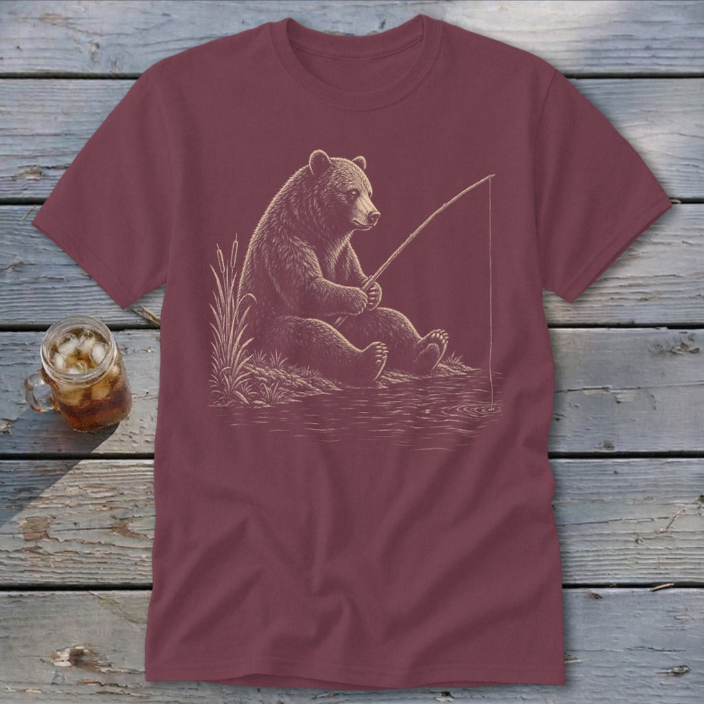 Maroon t-shirt with a bear fishing on the water's edge.