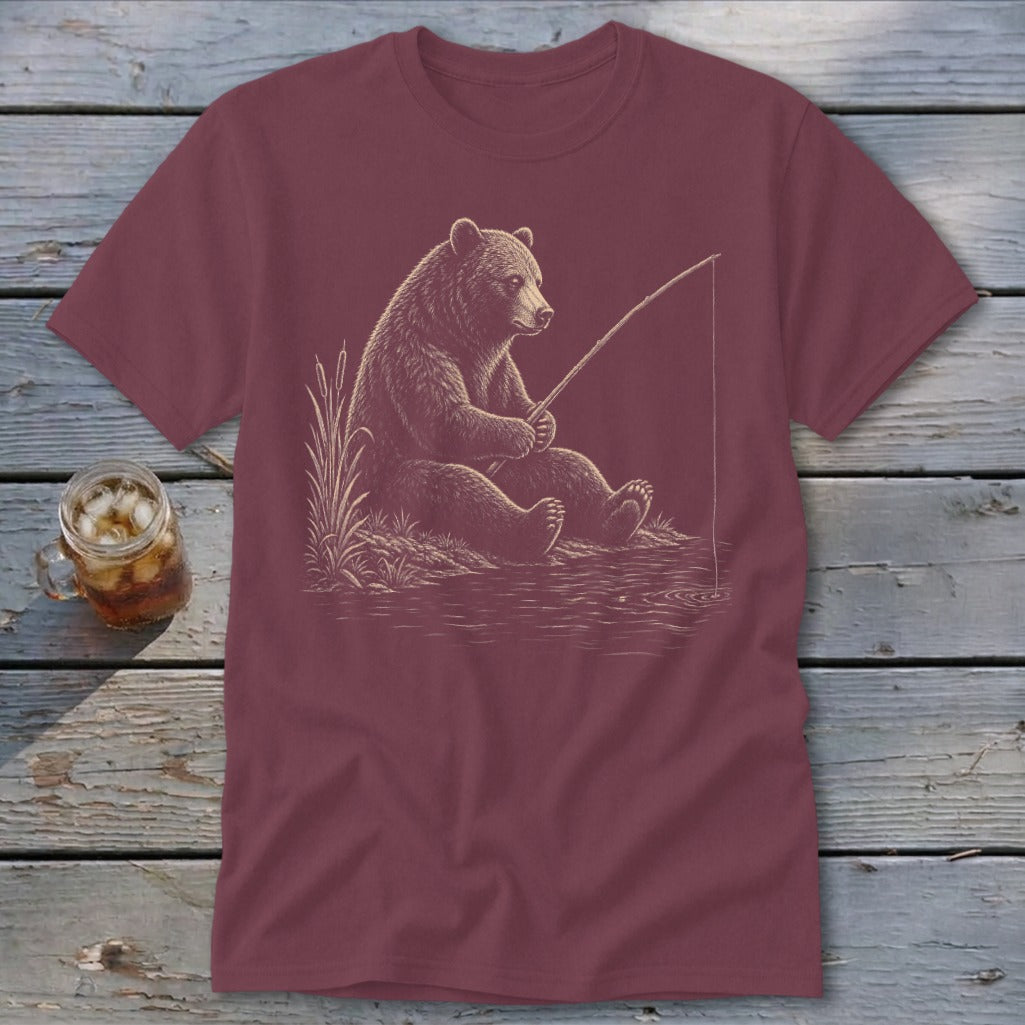 Maroon t-shirt with a bear fishing on the water's edge.