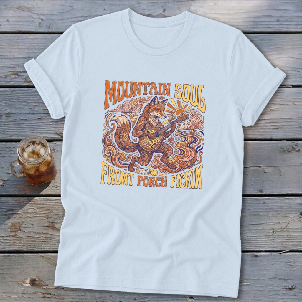 Fox playing guitar on light blue t-shirt with "Mountain Soul and Front Porch Pickin'" text.