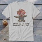 White t-shirt with anvil graphic, blooming flowers, and text "FORGED IN FIRE ROOTED IN STONE".