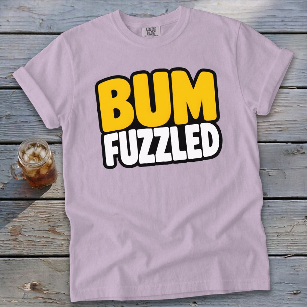 Light purple crewneck t-shirt with rolled sleeves featuring bold text saying BUM FUZZLED on a wooden background.