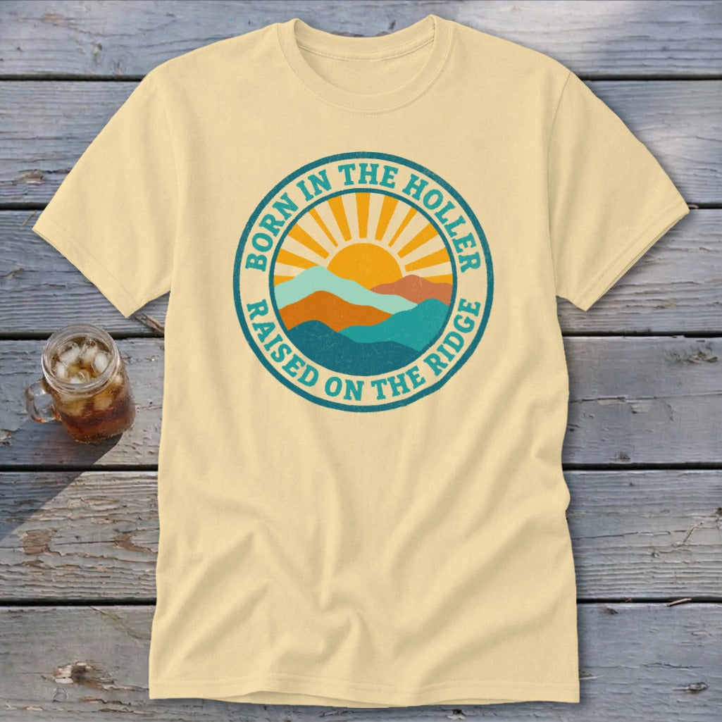 Cream-colored crewneck t-shirt featuring a retro circular graphic with mountains, a rising sun, and text.
