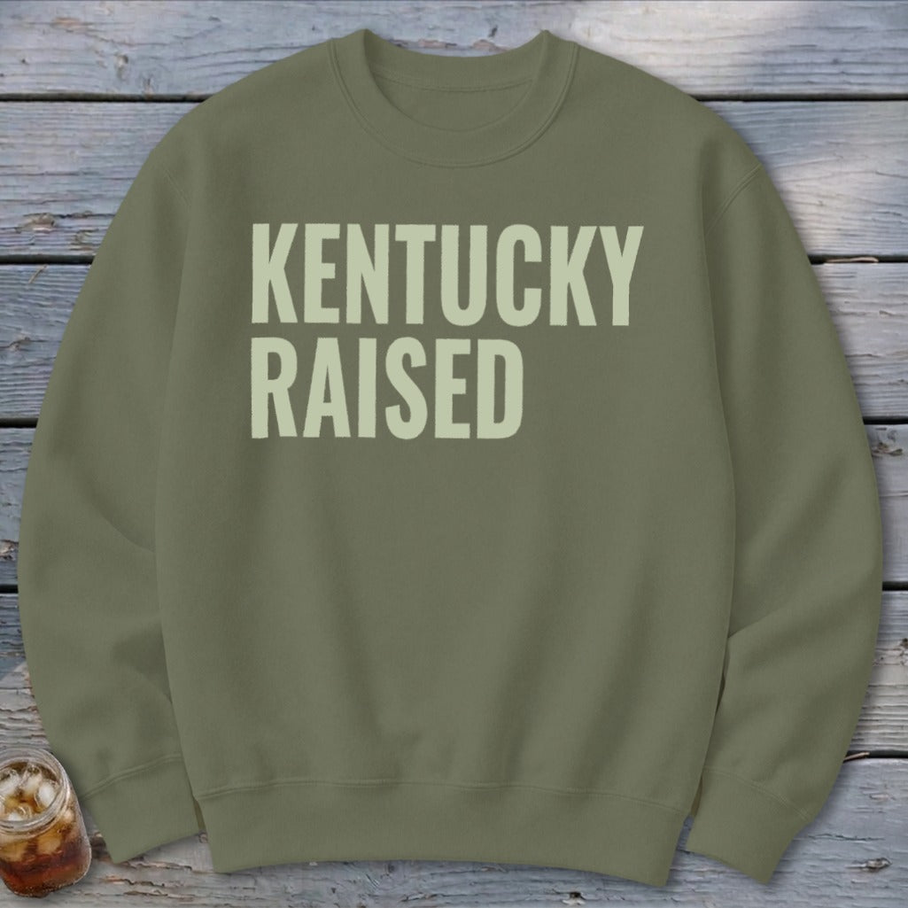 Olive green crewneck sweatshirt with "KENTUCKY RAISED" text in light cream.