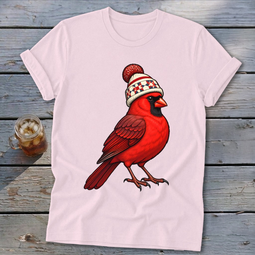 Light pink short-sleeved t-shirt featuring a graphic of a bright red cardinal wearing a winter hat.