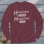 Maroon long-sleeve shirt with white text reading "Mountain Raised Mountain Made".