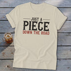 Cream t-shirt with text "JUST A PIECE DOWN THE ROAD"