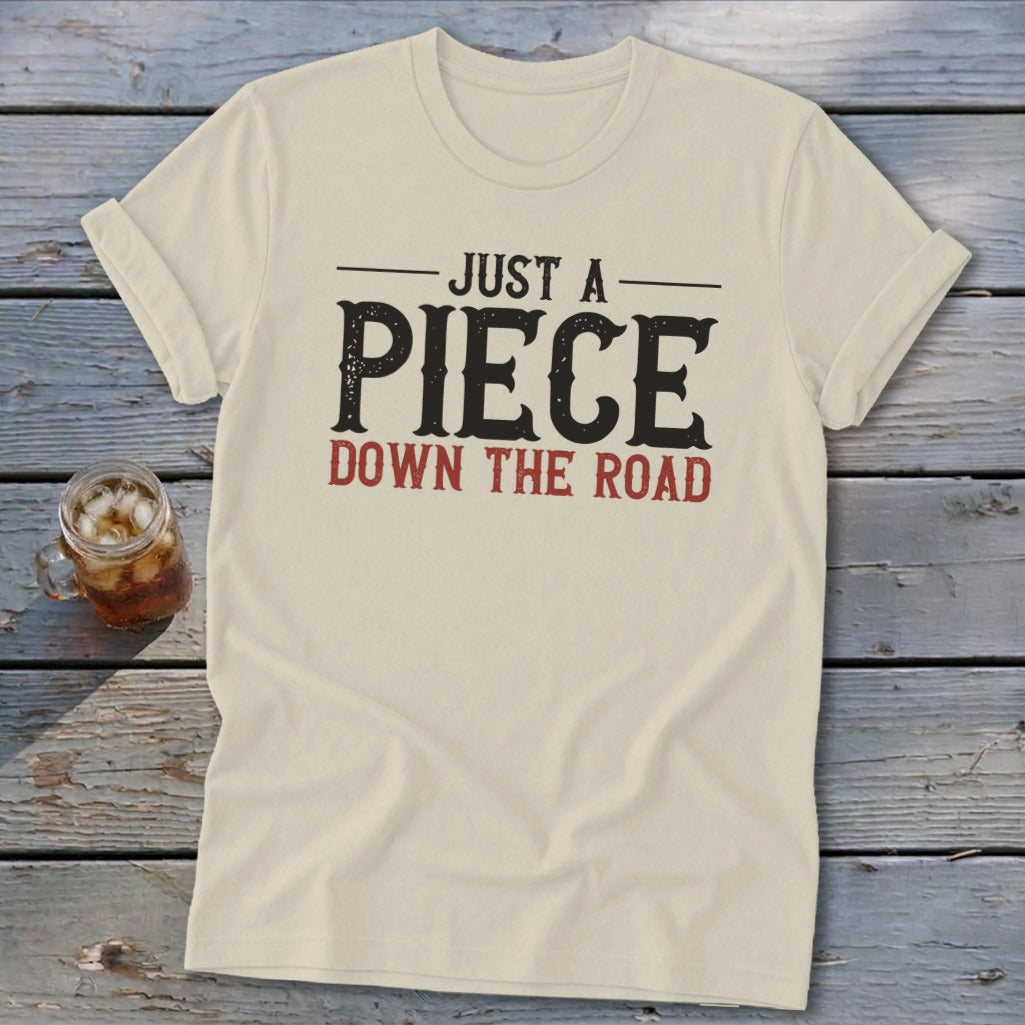 Cream t-shirt with text "JUST A PIECE DOWN THE ROAD"