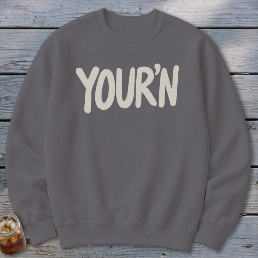 Gray sweatshirt with "YOUR'N" printed in cream, soft, rounded font.