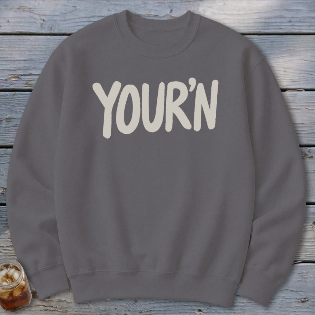 Gray sweatshirt with "YOUR'N" printed in cream, soft, rounded font.