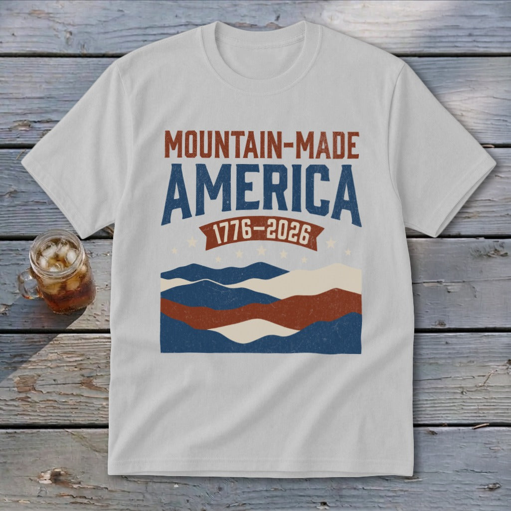 Light gray crewneck t-shirt featuring a red, white, and blue Mountain-Made America graphic and 1776-2026 banner.