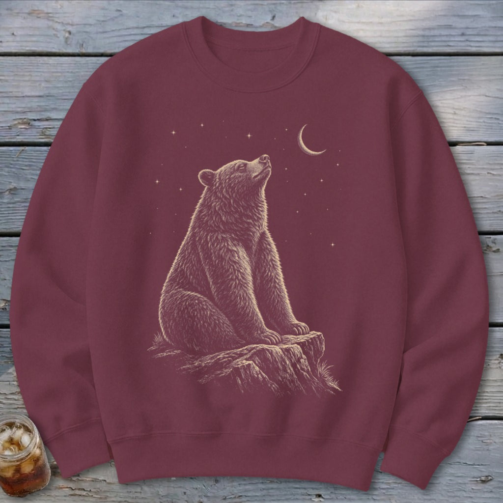 Maroon sweatshirt with a detailed illustration of a bear looking at a crescent moon and stars.