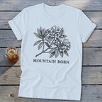 Light blue t-shirt with black sketch of mountain laurel and "MOUNTAIN BORN" text.