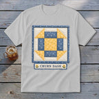 White t-shirt with a Churn Dash quilt block graphic and text.