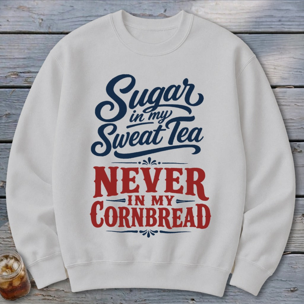 A light gray crewneck sweatshirt features blue and red typography reading Sugar in my Sweet Tea, NEVER IN MY CORNBREAD.