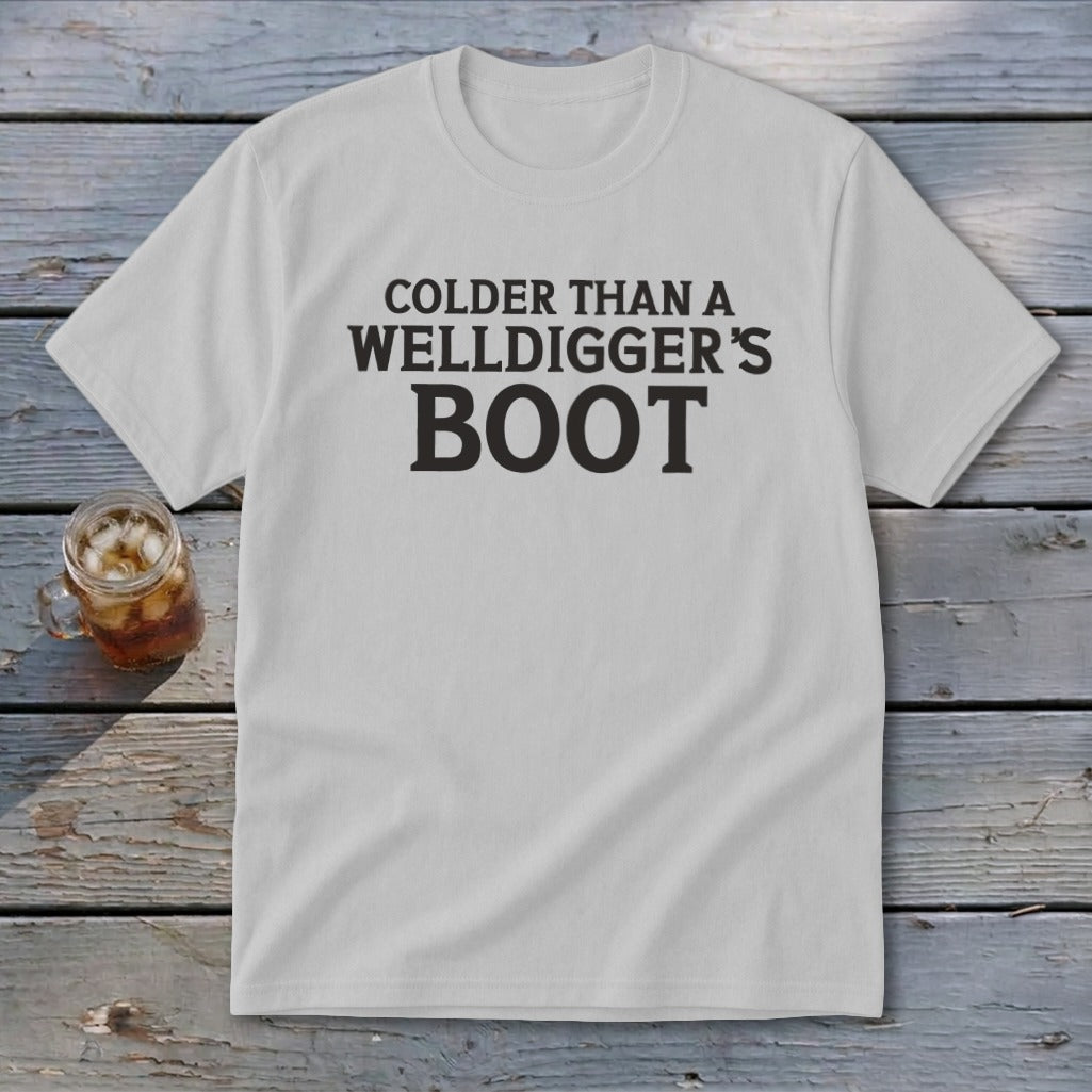 White t-shirt with black text reading "Colder Than A Welldigger's Boot".