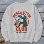 White sweatshirt with a bear drinking from a jar, text reads "Porch Sittin' Club est. after supper".