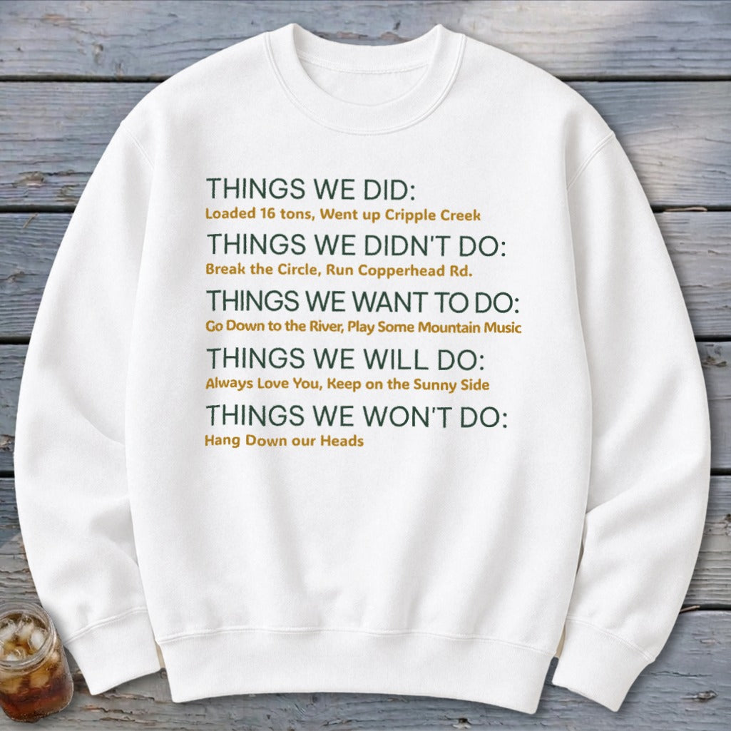 White sweatshirt with green and yellow text listing things done, not done, wanted, will do, and won't do.
