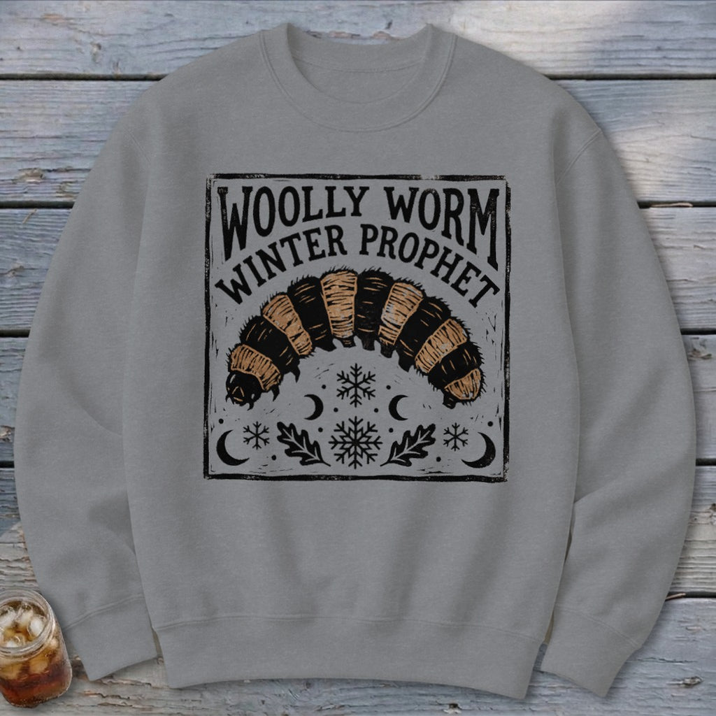 Grey crewneck sweatshirt featuring a block-print graphic of a woolly worm with text reading Woolly Worm Winter Prophet.