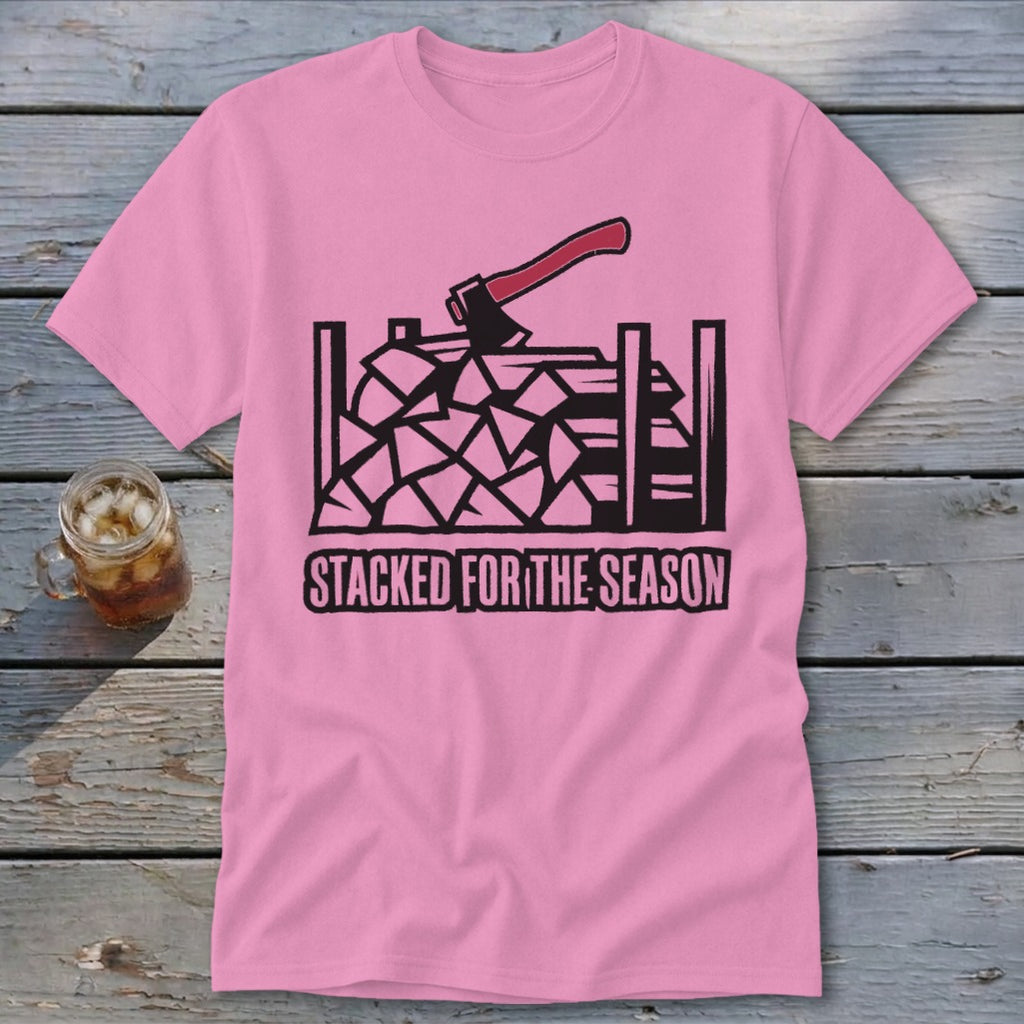 Pink t-shirt with black graphic of stacked firewood, axe, and text "STACKED FOR THE SEASON".
