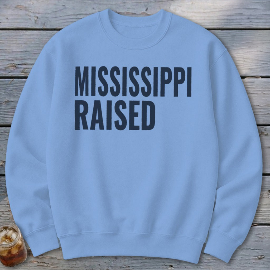 Light blue crewneck sweatshirt with "MISSISSIPPI RAISED" printed in dark blue text.