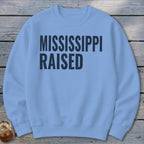 Light blue crewneck sweatshirt with "MISSISSIPPI RAISED" printed in dark blue text.