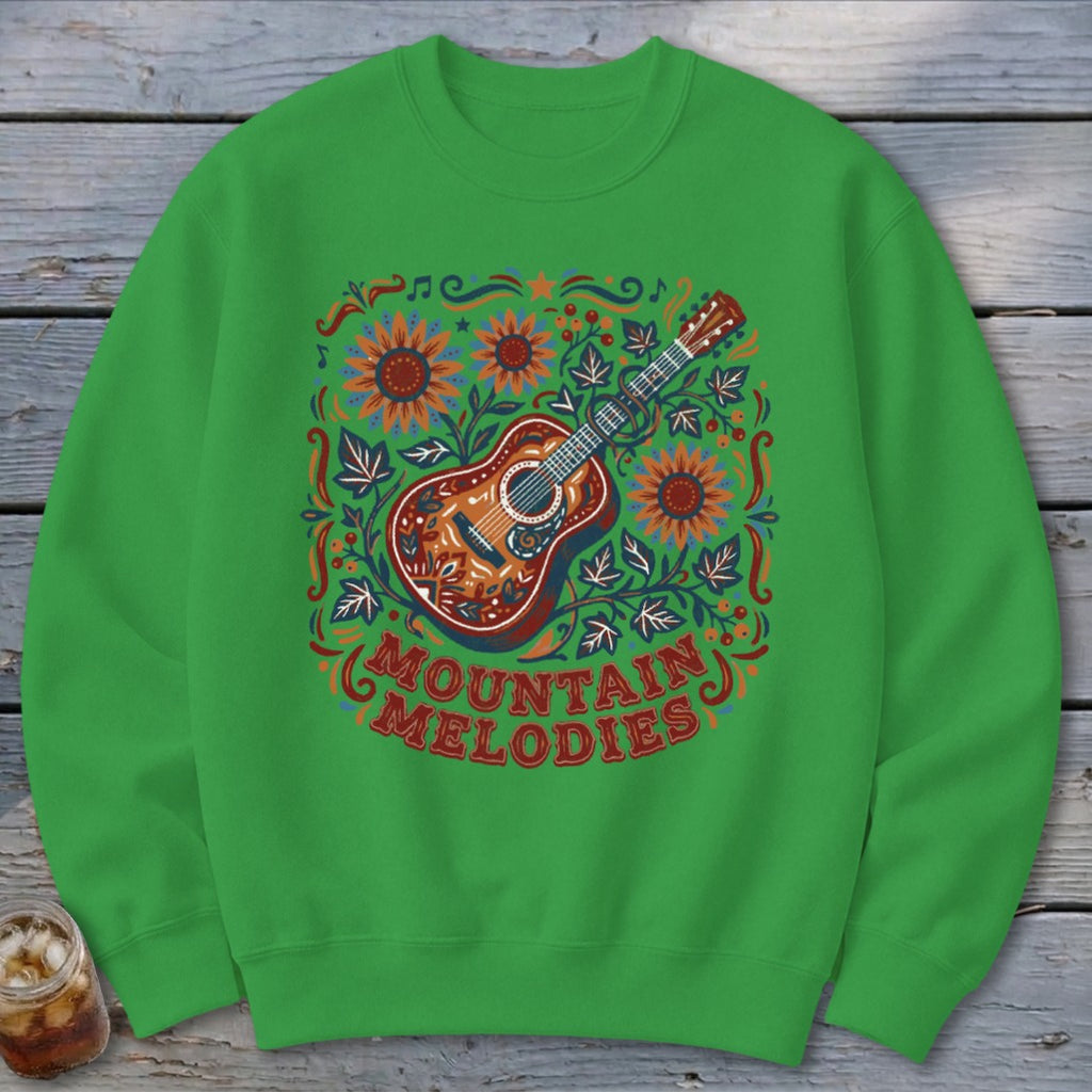 Bright green sweatshirt featuring a colorful folk art guitar graphic with flowers and Mountain Melodies text.