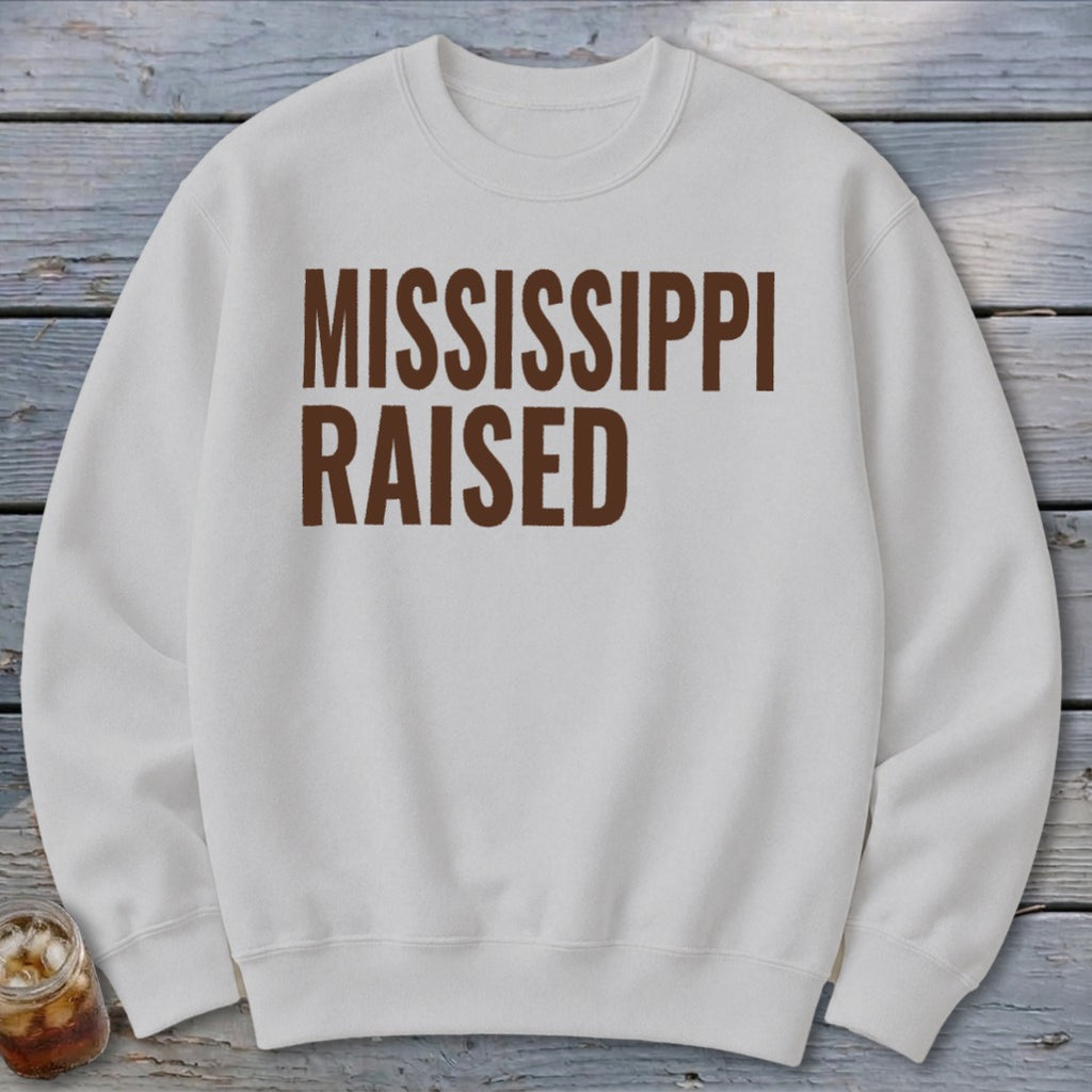 White sweatshirt with brown text reading "MISSISSIPPI RAISED".