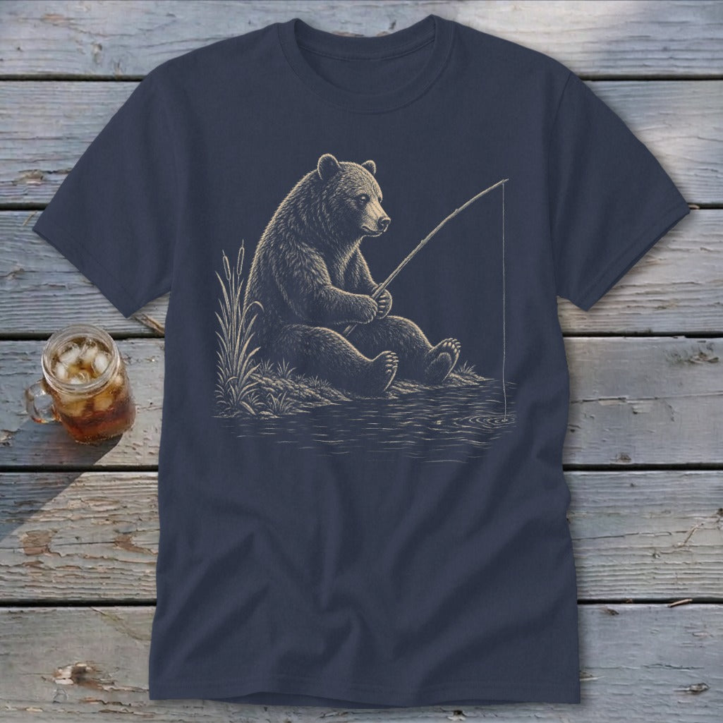 Bear sitting by the water, holding a fishing rod, on a navy t-shirt.