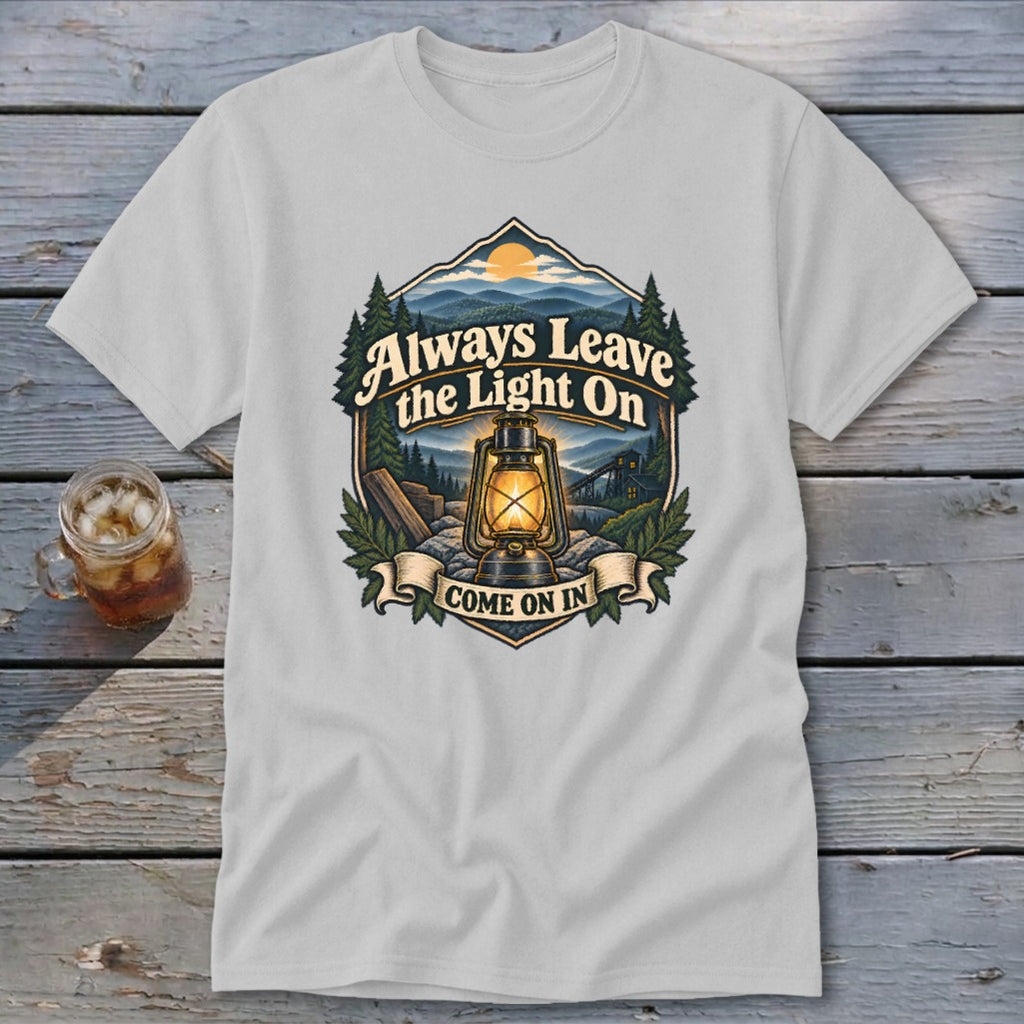 T-shirt graphic with lantern, mountains, and text "Always Leave the Light On Come On In."