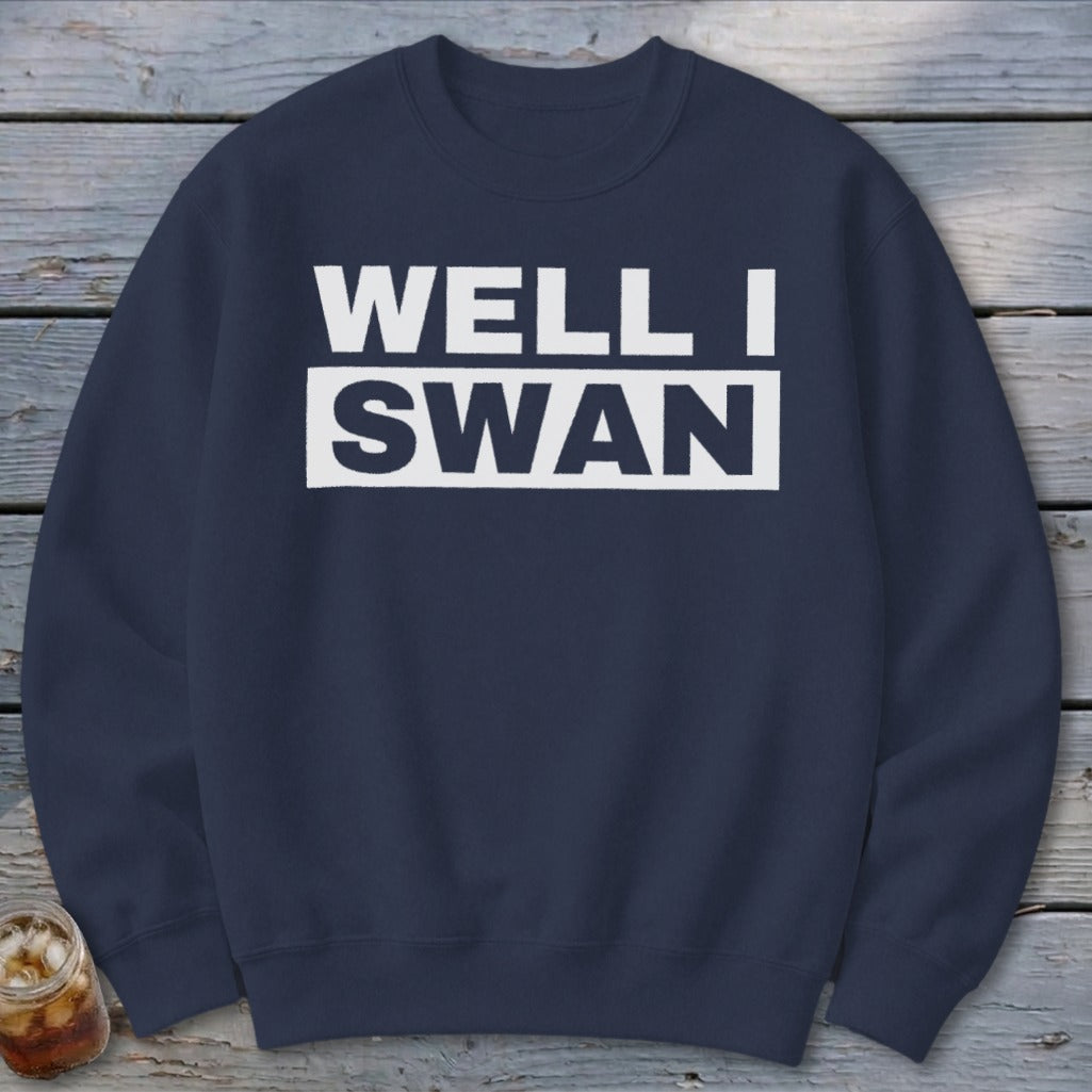 A dark blue crewneck sweatshirt with the white text "WELL I SWAN" printed on the chest.