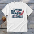 White t-shirt with distressed American flag graphic and text "TENNESSEE RAISED AMERICAN MADE".