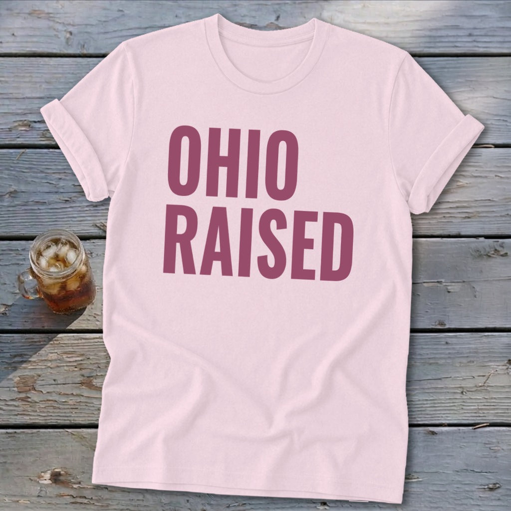 Pink t-shirt with large purple text reading "OHIO RAISED".