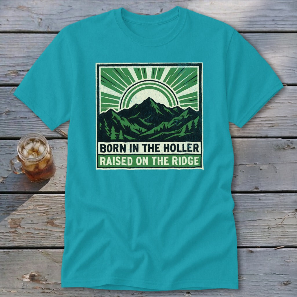 Teal crewneck t-shirt featuring a green graphic of mountains, trees, and the text Born in the Holler, Raised on the Ridge.