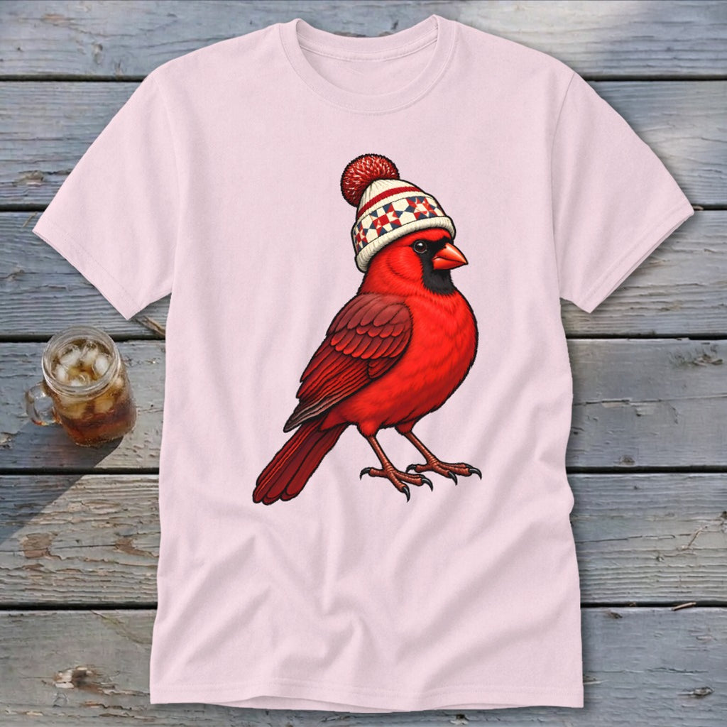 A light pink t-shirt displays an illustration of a red cardinal wearing a winter hat with a pom-pom.