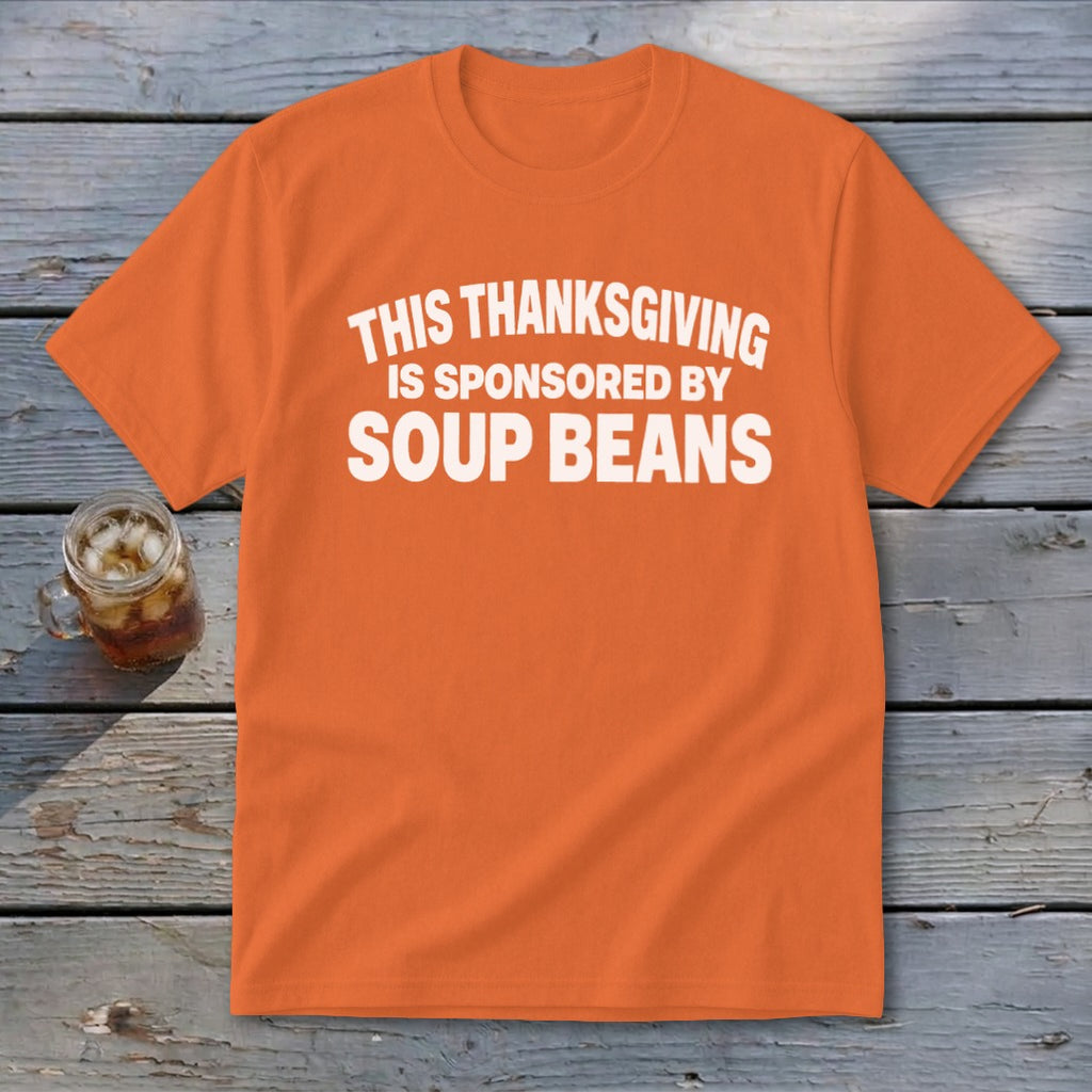An orange t-shirt featuring the white text "THIS THANKSGIVING IS SPONSORED BY SOUP BEANS."