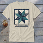 Light t-shirt with an embroidered eight-pointed star quilt design and text.