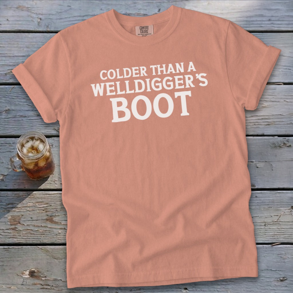 Peach t-shirt with white text reading "Colder Than A Welldigger's Boot".