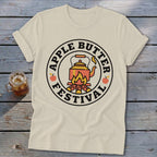 Cream t-shirt with "Apple Butter Festival" text and kettle over a campfire graphic.