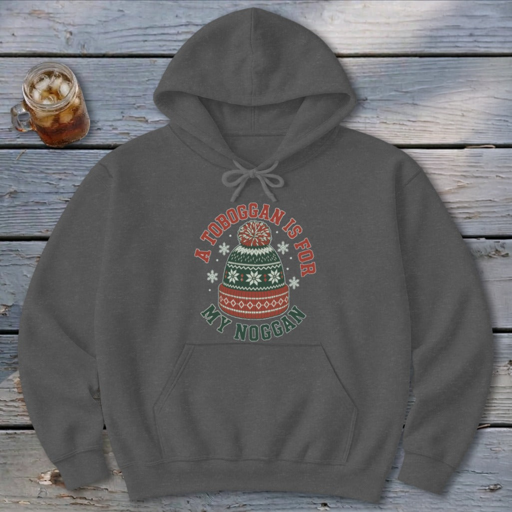 Dark grey hooded sweatshirt featuring a graphic of a winter hat with text reading A TOBOGGAN IS FOR MY NOGGAN.