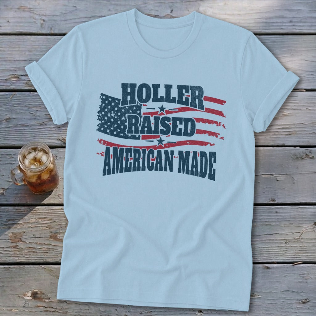 Light blue t-shirt with distressed American flag graphic and text "HOLLER RAISED AMERICAN MADE".