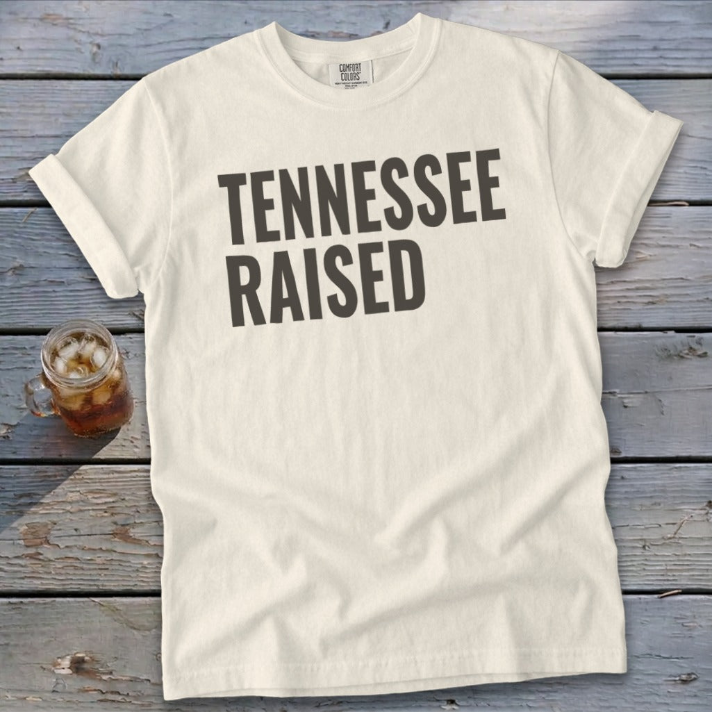 Cream t-shirt with "TENNESSEE RAISED" printed in dark gray text.