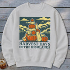 A cream-colored crewneck sweatshirt featuring a graphic of stacked pumpkins with text reading Harvest Days in the Highlands.